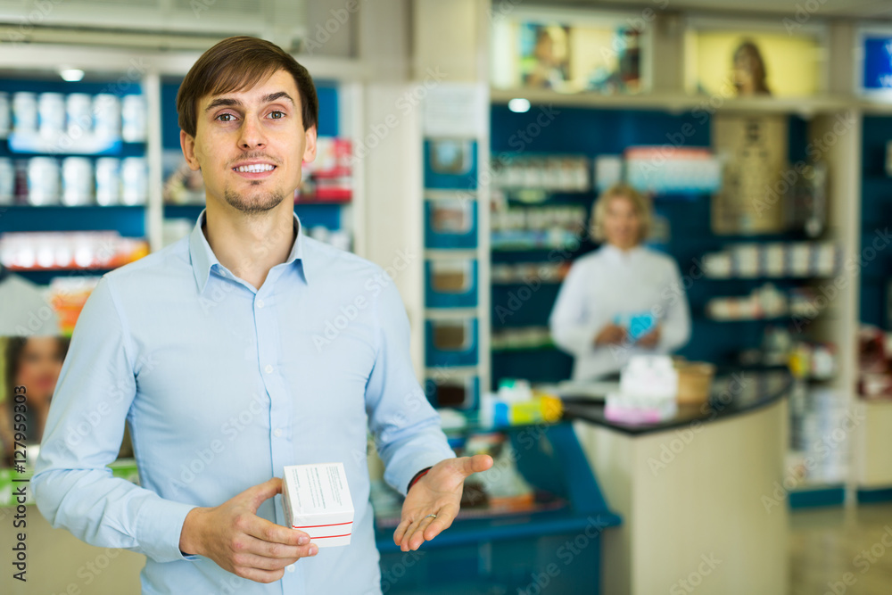 Man near counter in pharmacy