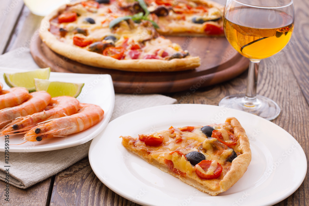 Big tasty pizza with seafood, tomatoes, wine on wooden table Big tasty pizza with seafood, tomatoes, wine on wooden table