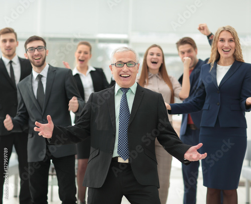 Mature businessman and cheerful business team on office backgrou