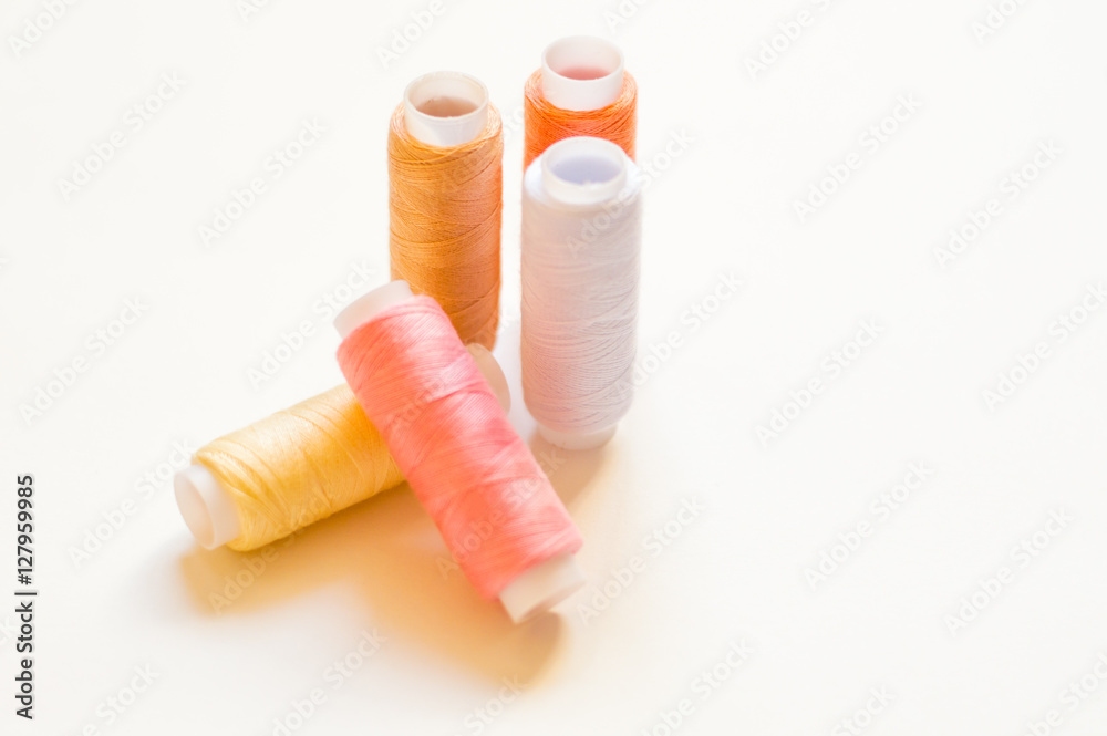 multicolored spools of thread on white background multicolored spools of thread on white background