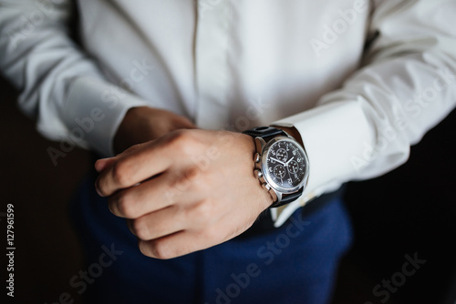 Rehearsal preparation. Groom's watches on hand. High angle view