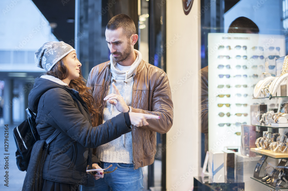 Fototapeta premium Young man explains to his girlfriend that there is no money to buy her something she is looking for
