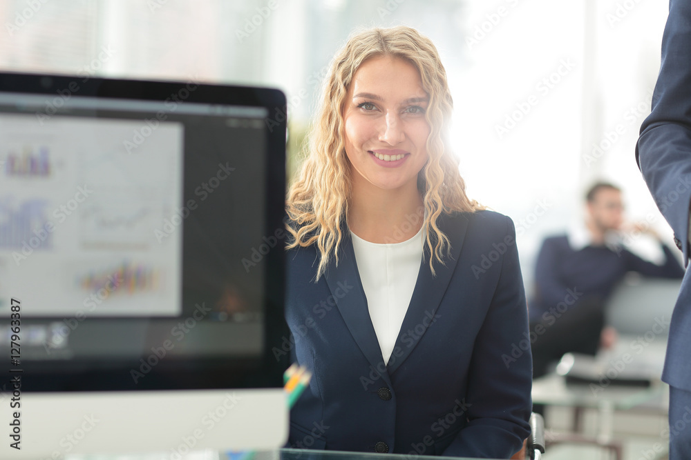 Young business woman standing with her collegues in background a Young business woman standing with her collegues in background a