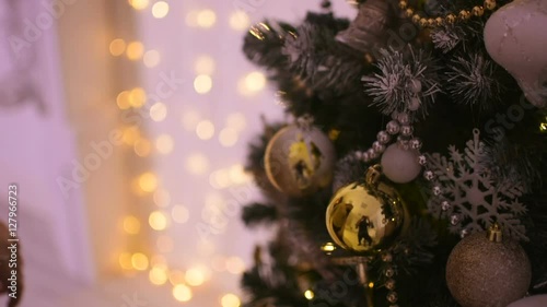 A delicate and beautiful hands of young woman decorating the tree Christmas toys.