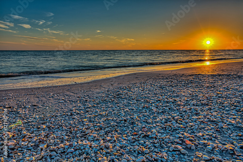 Fototapeta Naklejka Na Ścianę i Meble -  A sunset into the Gulf of Mexico from the beach on Sanibel Island, Florida.