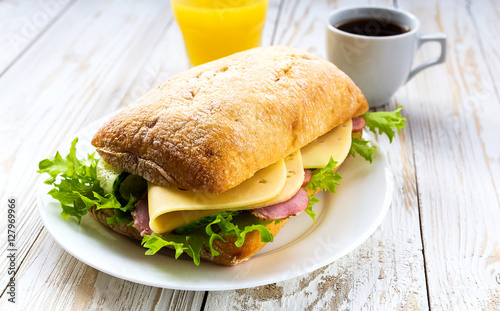 Chiabatta sandwich, cup of coffee and orange juice