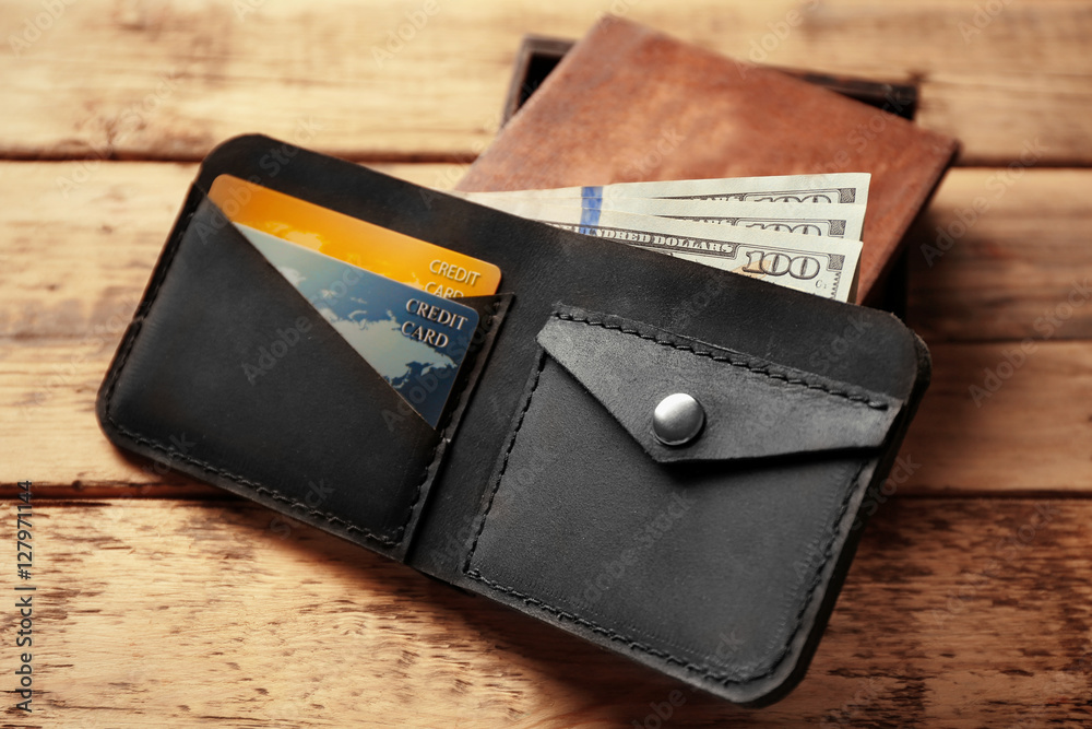 Stylish leather wallet with money and box on wooden background Stylish leather wallet with money and box on wooden background