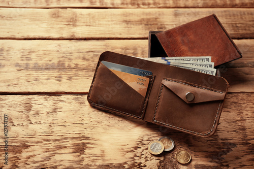 Stylish leather wallet with money and box on wooden background