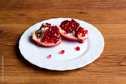 Pomegranate slices and garnet fruit seeds on table. Pomegranate whole. Use