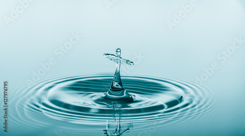 Water drop falling and drips on water mirror. Water drop splash and make perfect circles on water surface
