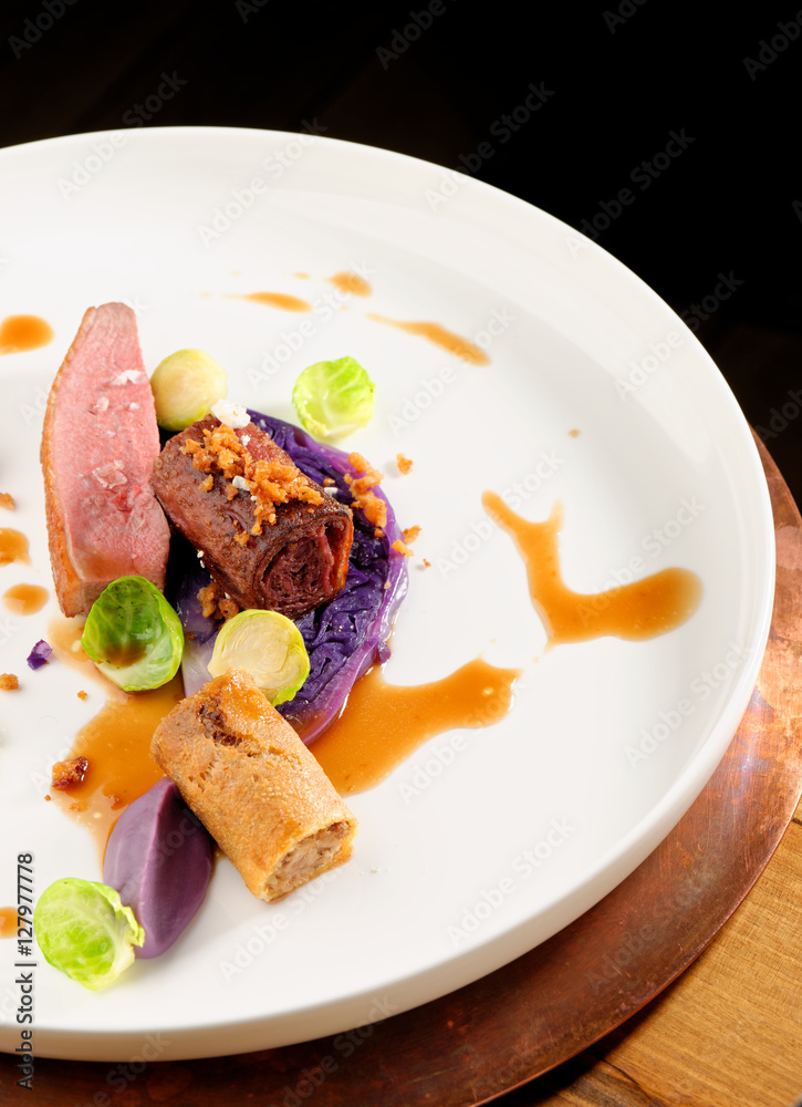 Roast duck, red cabbage roll and dry fruits in fine dining restaurant Roast duck, red cabbage roll and dry fruits in fine dining restaurant