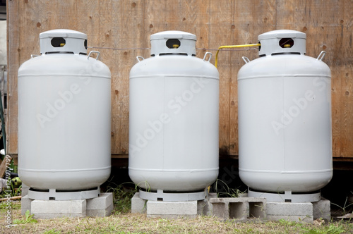 Obraz na płótnie Three gray propane tanks. Horizontal.
