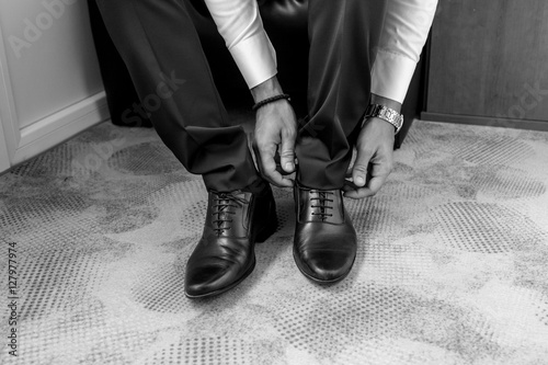 Groom tying shoelaces.