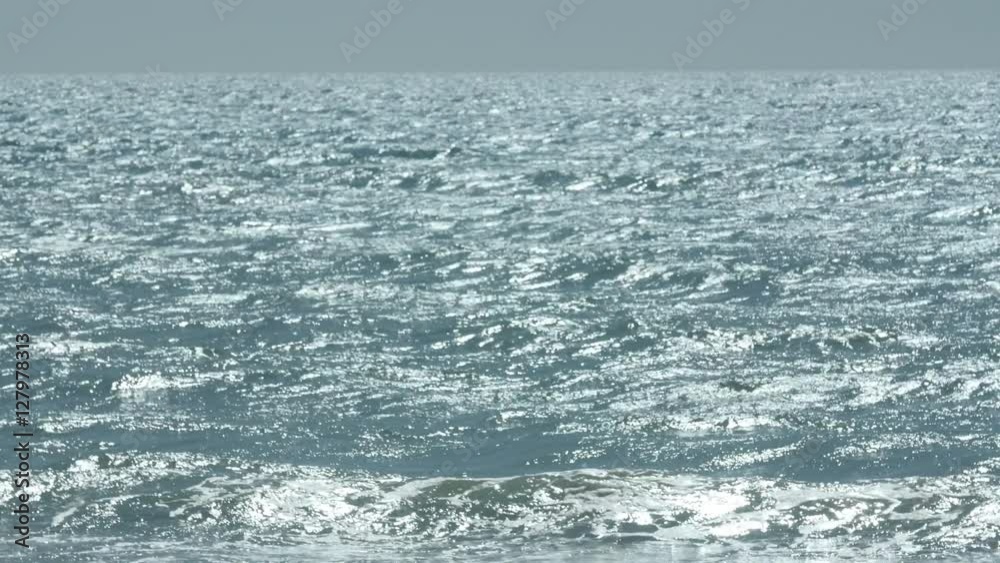 Shot of a wide, endless ocean with sunlight hitting off its surface. Summertime. Shot of a wide, endless ocean with sunlight hitting off its surface. Summertime.