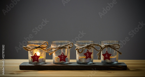 Four Advent candles on grey