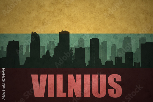 abstract silhouette of the city with text Vilnius at the vintage lithuanian flag