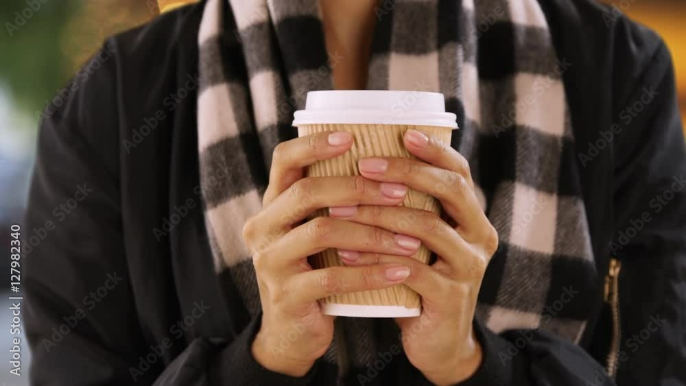 Closeup of black woman's hands holding paper cup. Portrait of hands holding cup.