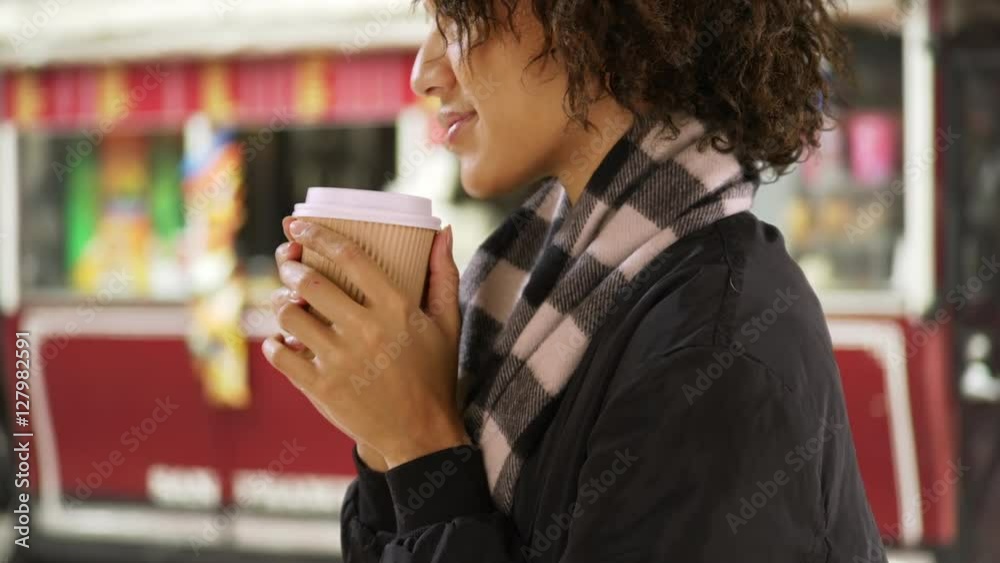 Portrait of young hipster woman holding paper cup, standing by a food stand. Portrait of young hipster woman holding paper cup, standing by a food stand.