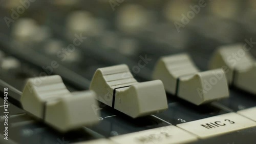 Professional audio mixing console with faders and adjusting knobs - radio photo