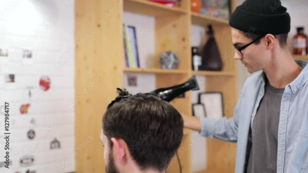 Barber combing the hair of the client before haircut at a barber shop Barber combing the hair of the client before haircut at a barber shop