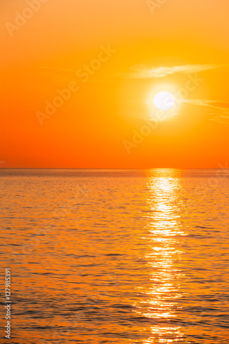 Sun Is Setting On Horizon At Sunset Sunrise Over Sea Or Ocean. T © Grigory Bruev
