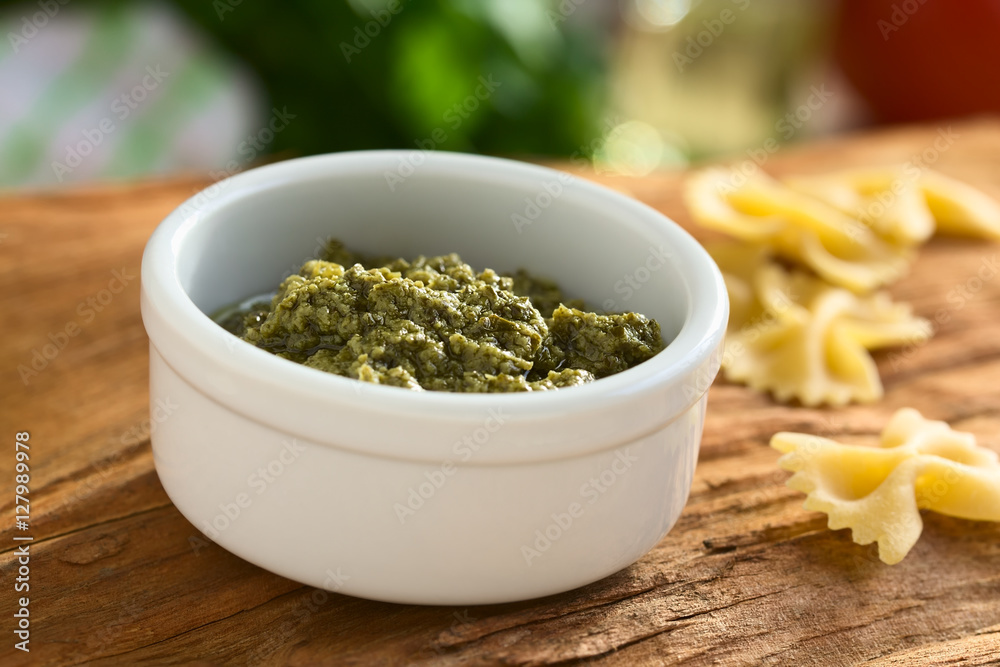 Pesto alla Genovese zubereitet aus Basilikum, Pinienkerne, Olivenöl und Knoblauch in kleiner Schüssel, fotografiert mit natürlichem Licht (Selektiver Fokus, Fokus in die Mitte des Pestos) Pesto alla Genovese zubereitet aus Basilikum, Pinienkerne, Olivenöl und Knoblauch in kleiner Schüssel, fotografiert mit natürlichem Licht (Selektiver Fokus, Fokus in die Mitte des Pestos)