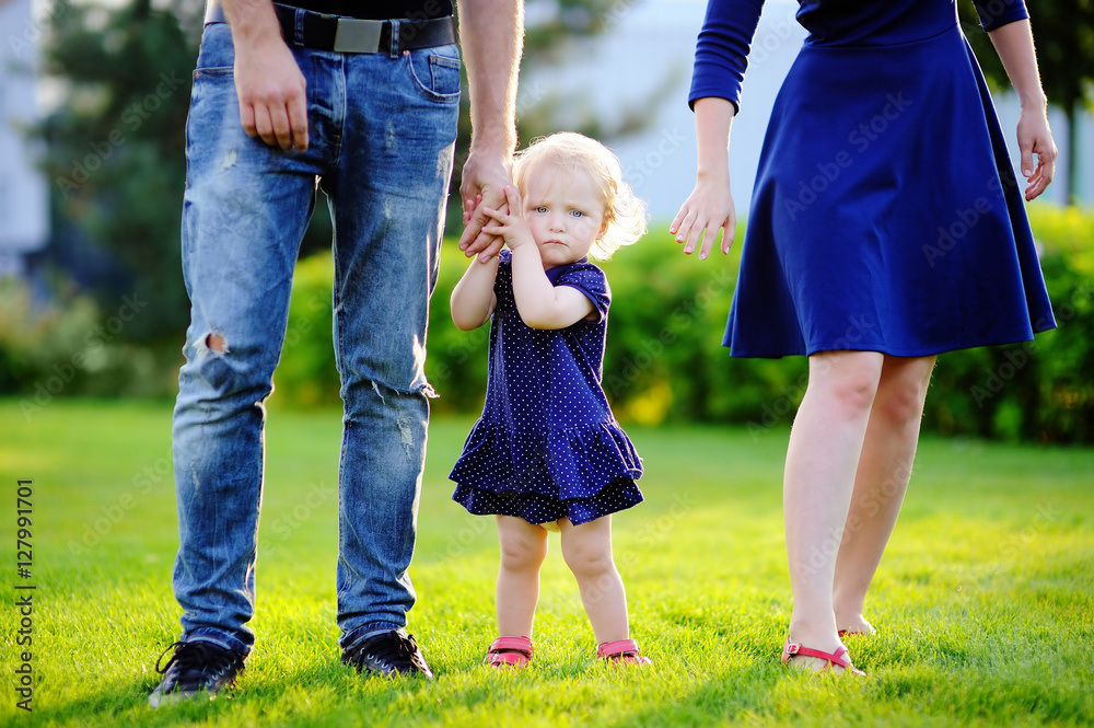Happy parenthood: young parents with their sweet toddler girl in Happy parenthood: young parents with their sweet toddler girl in