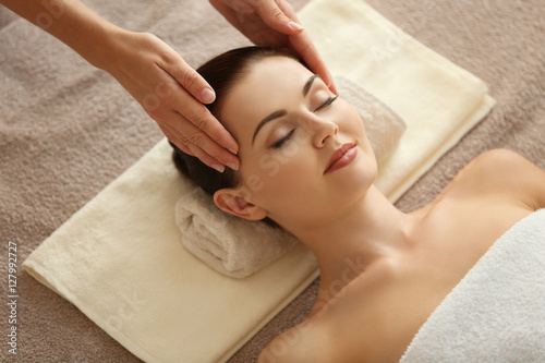 Spa concept. Young woman enjoying of facial massage in spa salon