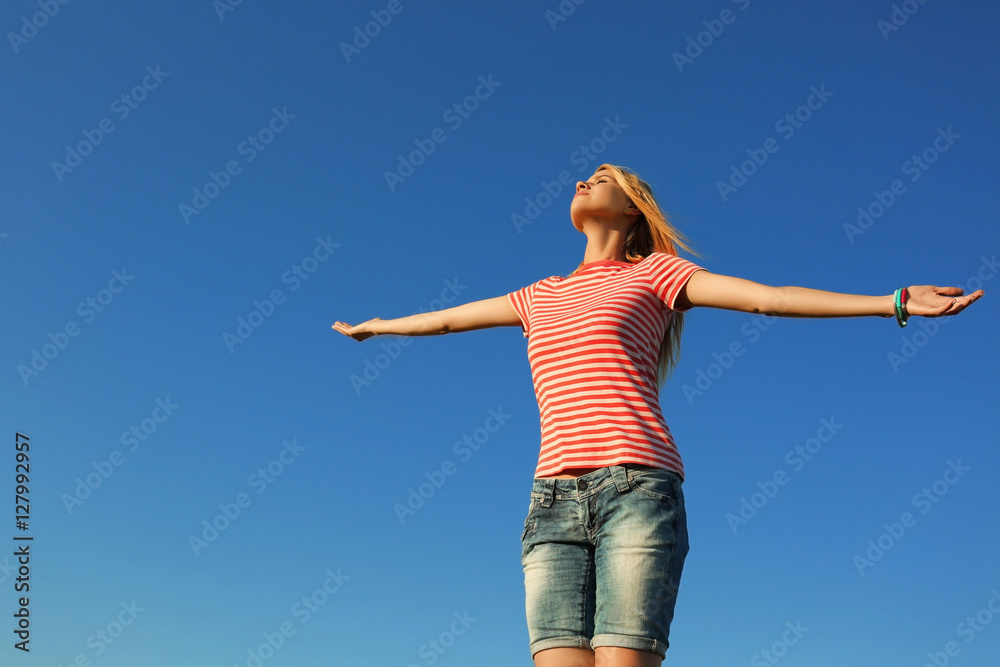 Happy young woman on blue sky background Happy young woman on blue sky background