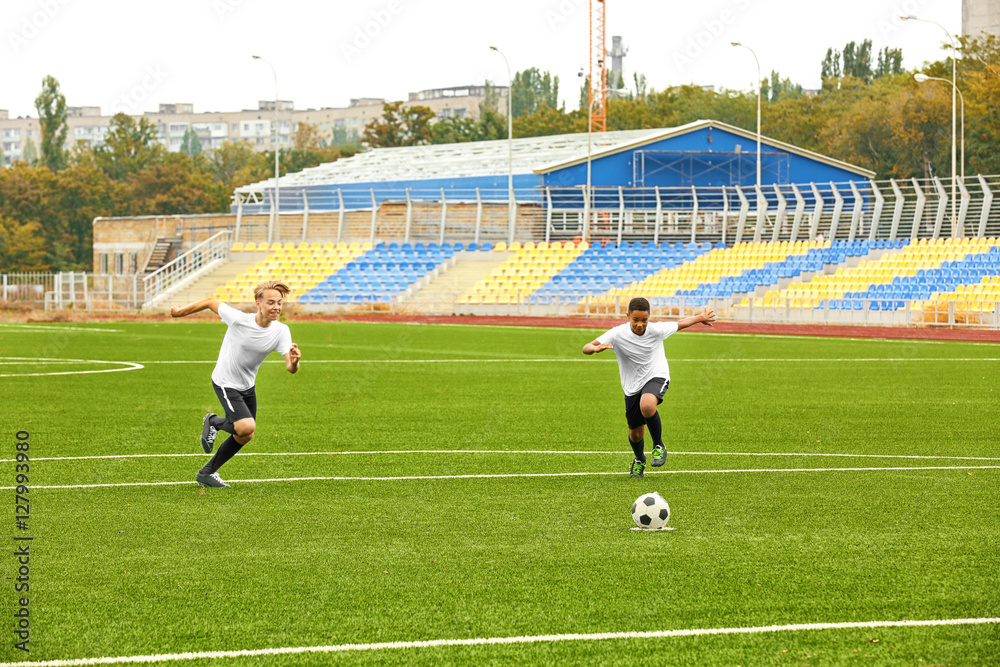 Fototapeta premium Boys playing football at stadium