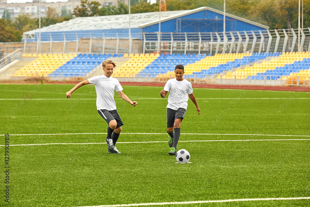 Obraz premium Boys playing football at stadium