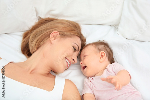 Young mother and baby lying on bed