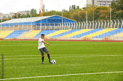 Boy playing football at stadium