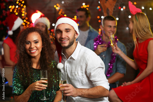 Canvas Print Young people with glasses of champagne at Christmas party