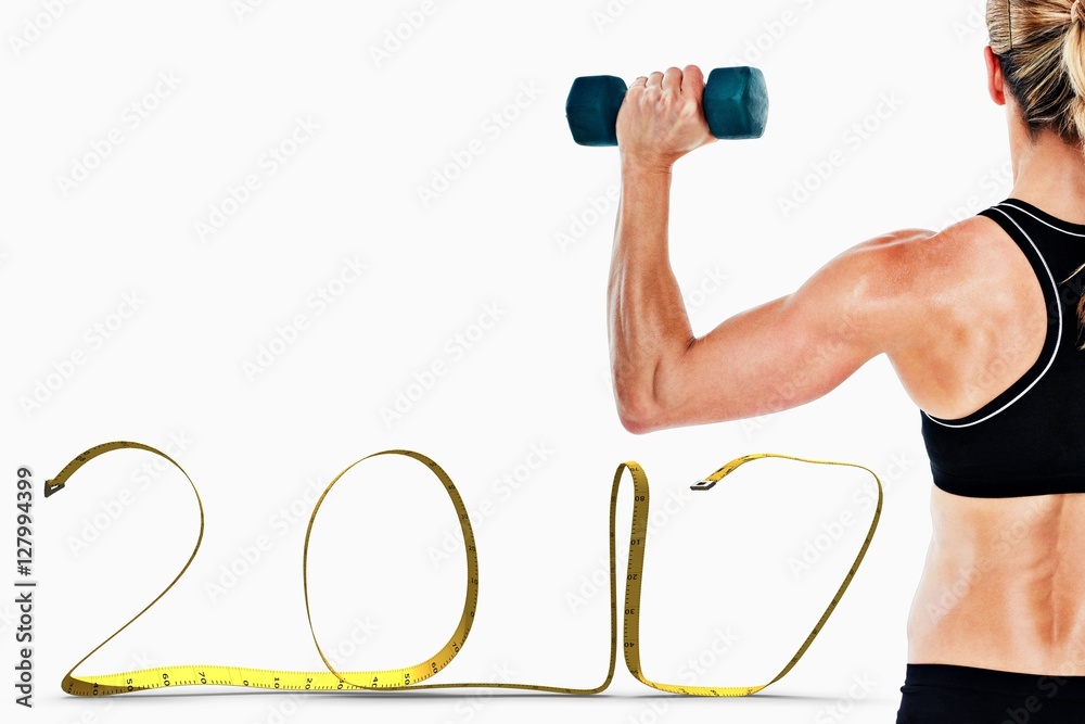 Composite image of female bodybuilder holding a blue dumbbell Composite image of female bodybuilder holding a blue dumbbell