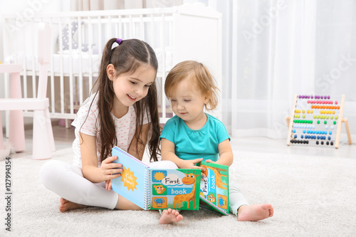 Cute girl reading book with...