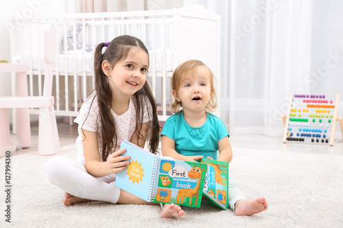 Cute girl reading book with...