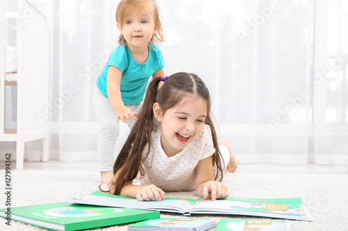 Cute girl reading book with...