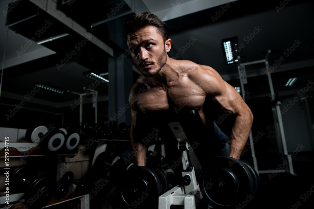 Muscular Man Exercising Back With Dumbbells Muscular Man Exercising Back With Dumbbells