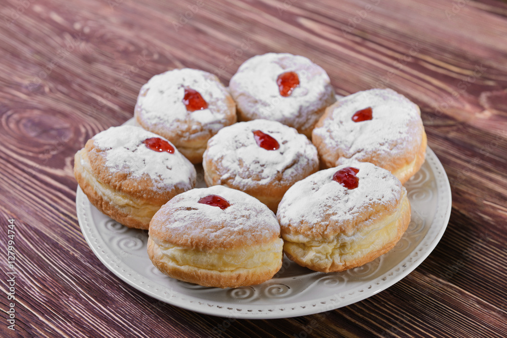 Plate with tasty donuts for Hanukkah on wooden table, closeup Plate with tasty donuts for Hanukkah on wooden table, closeup