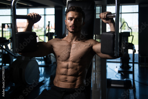 Man Doing Butterfly Chest Exercise On Machine
