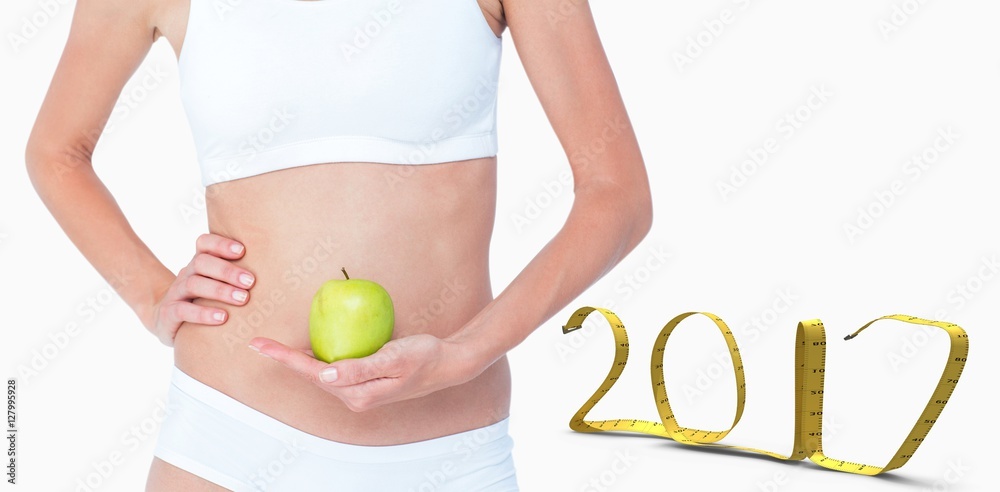 Composite image of woman holding an apple in front of her belly Composite image of woman holding an apple in front of her belly
