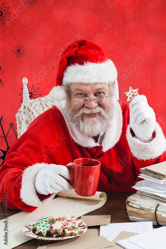 Composite image of portrait of cheerful santa claus holding coff photo