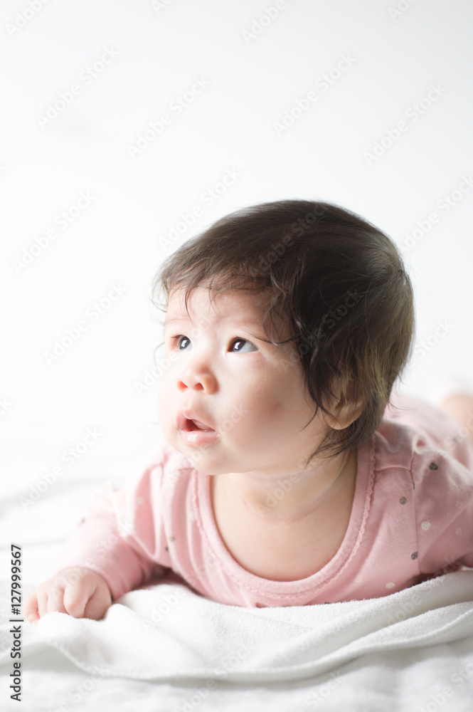 newborn baby girl in pink dress on white background