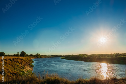 Sunset over the river and a small forest