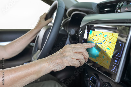 Elderly woman using GPS navigation system in car