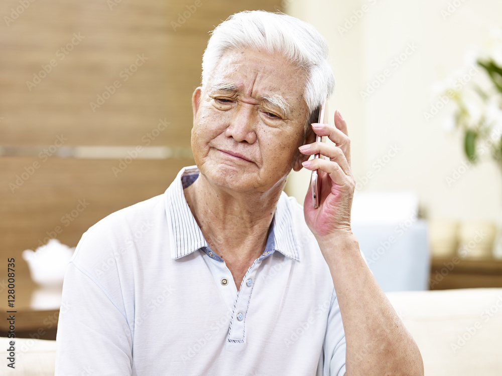 unhappy senior asian man talking on phone unhappy senior asian man talking on phone