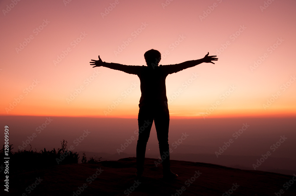 Fototapeta premium Girl opens arm with sunset sky background, inspiration and freedom concept