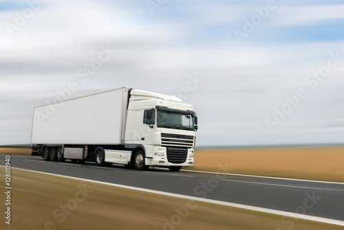 white heavy truck on a road motion blur