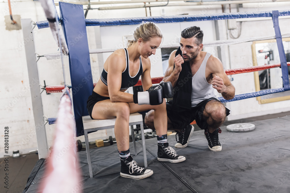 Coach talking to female boxer in boxing ring Coach talking to female boxer in boxing ring